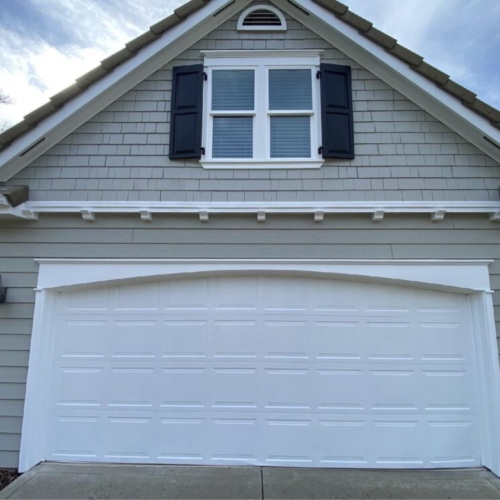 new grey siding with shutters and a white garage door