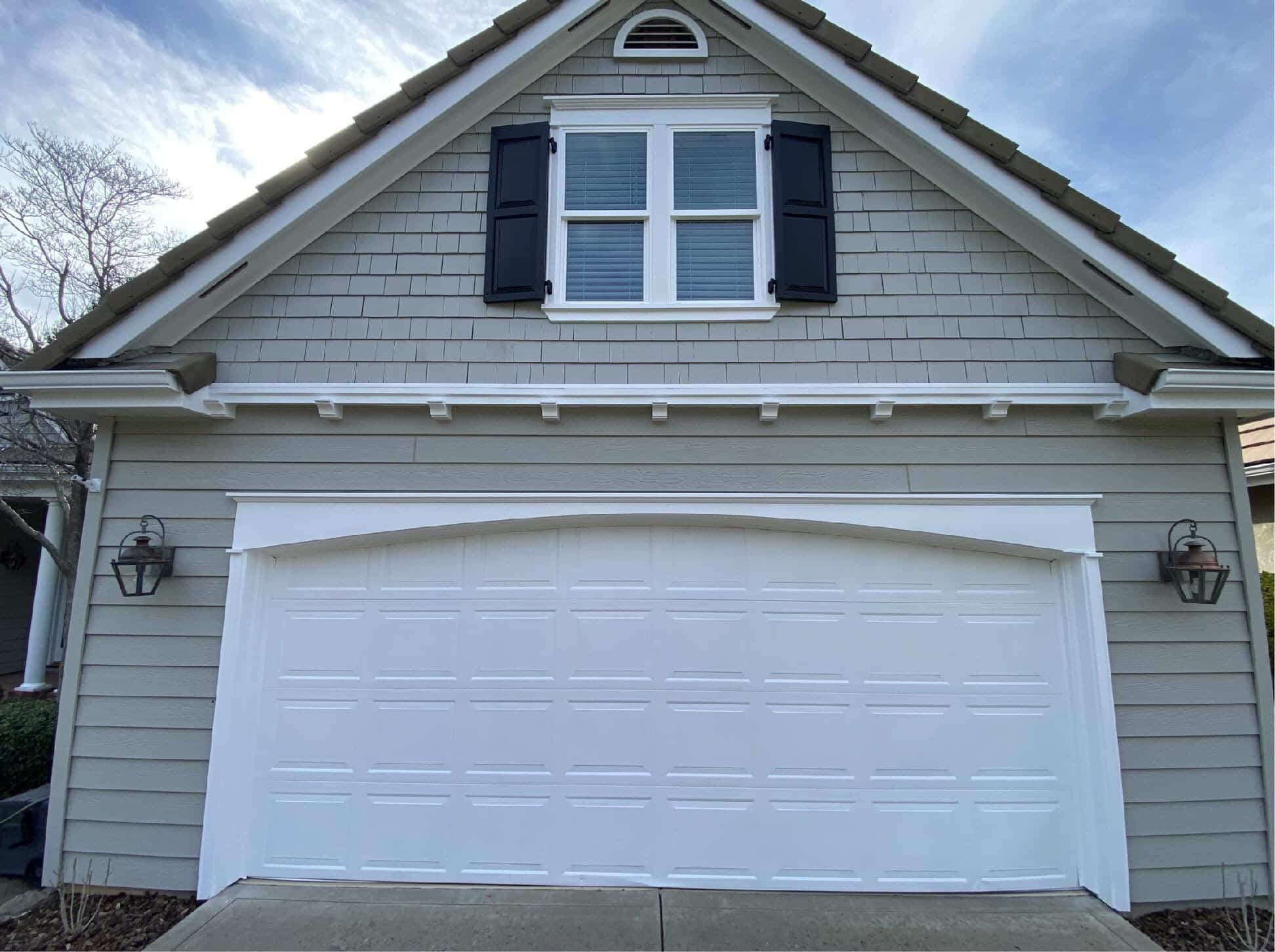 new grey siding with shutters and a white garage door